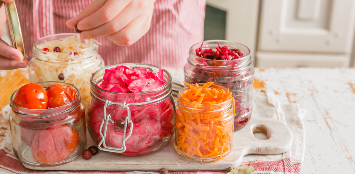 jars containing colorful vegetables are arranged on a counter