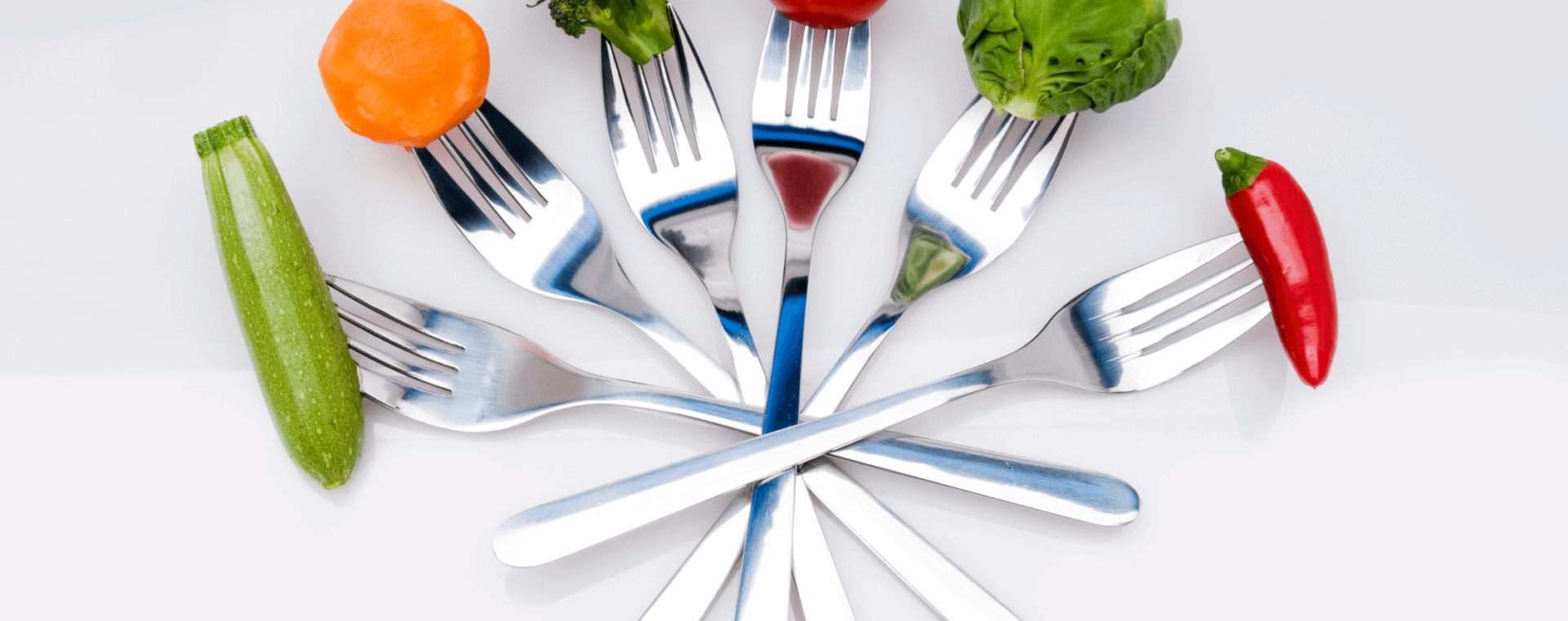 vegetables are held by forks in an arc shape