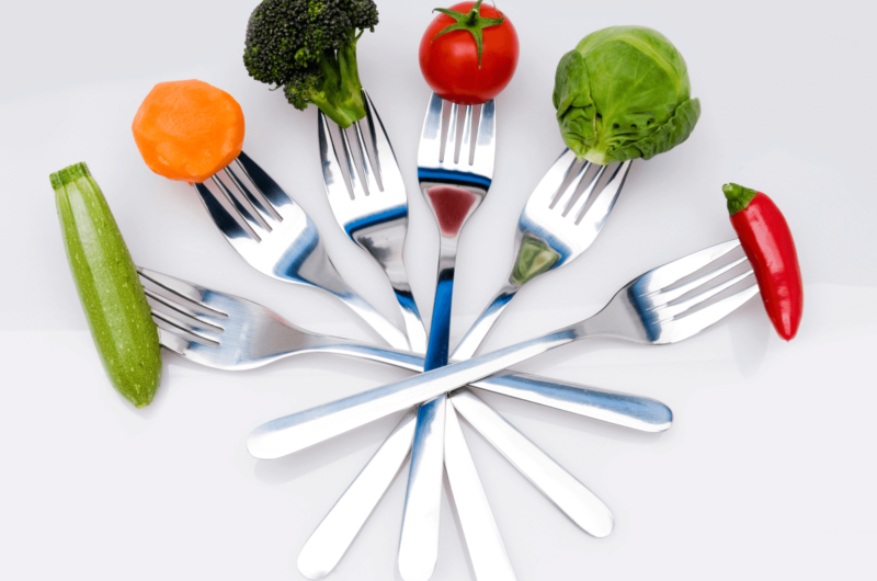 vegetables are held by forks in an arc shape