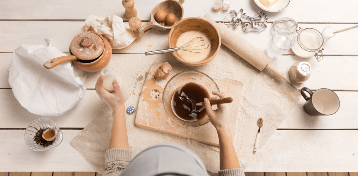 a person stands before ingredients and tools set out for baking